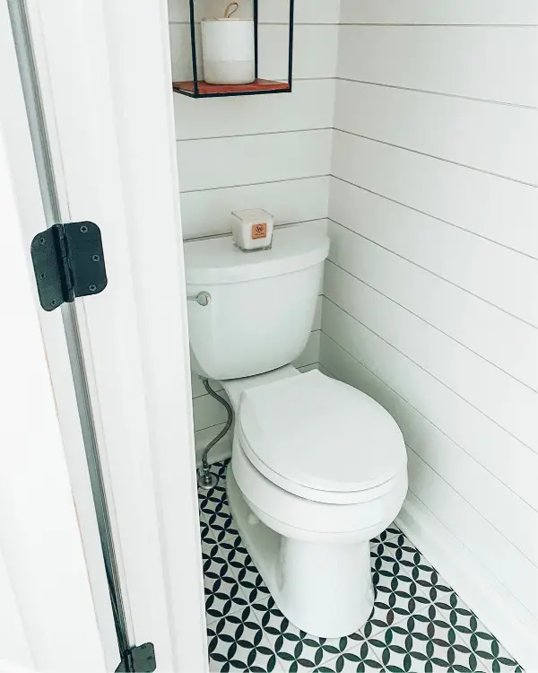 This shows how the white shiplap and light flooring make the small bathroom look larger.