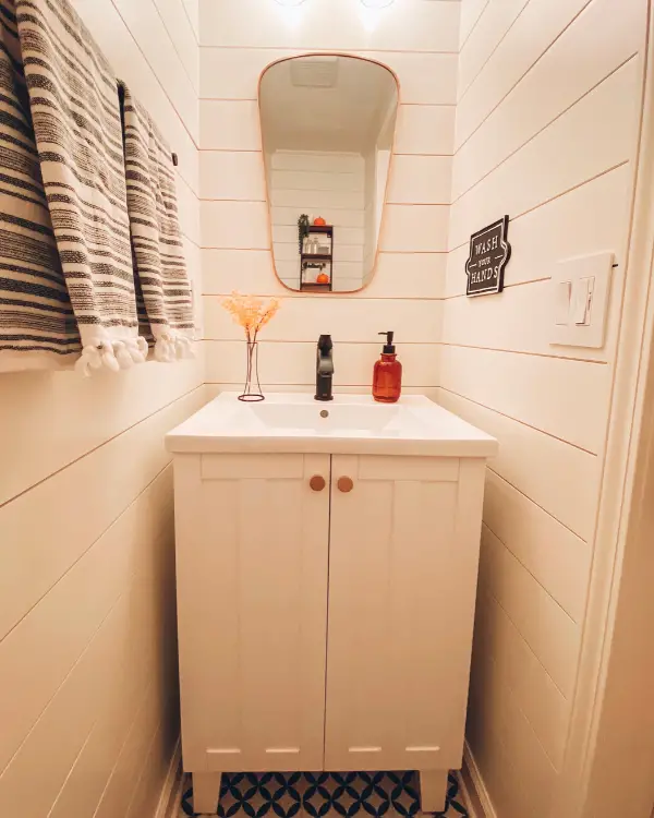 This shows how the white shiplap and free standing white vanity makes the small bathroom look larger.