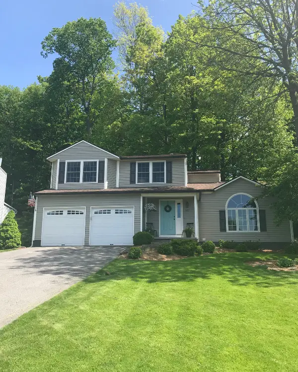 The exterior of the house is SW intellectual gray. The shutters are SW urbane bronze, the trim is SW alabaster and the door is SW festoon aqua.