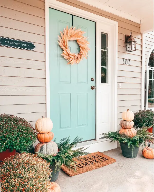 front porch decorated for Fall with pumpkin stacks