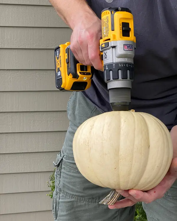 drilling the pumpkins to make the pumpkin stack