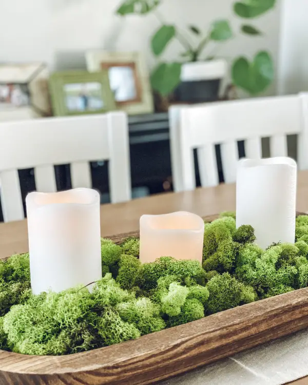 Moss and candles in a dough bowl on the dining room table
