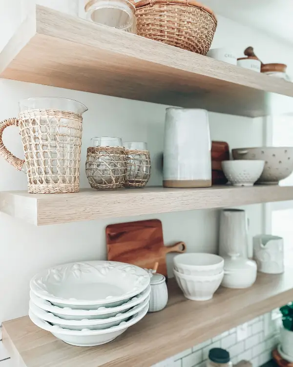 The floating shelves styled with neutral kitchen decor