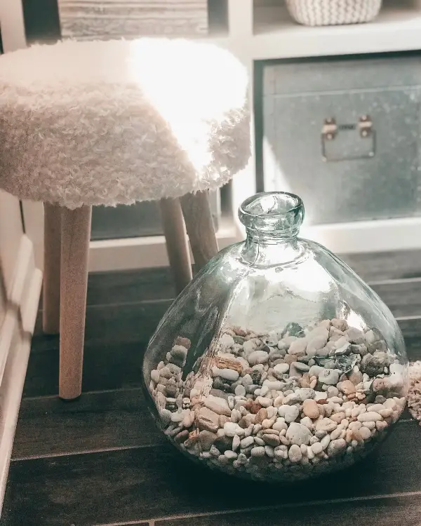 collecting shells and beach pebbles in a jar at home