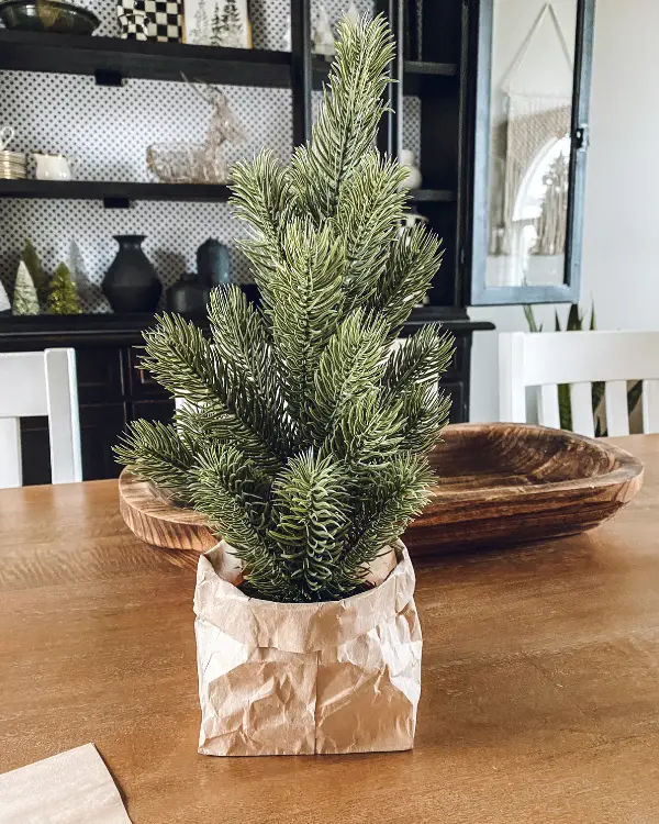 A Christmas tree in a crumpled brown paper bag
