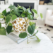 white planter with gold hearts decoupaged on it and a plant in it on a coffee table