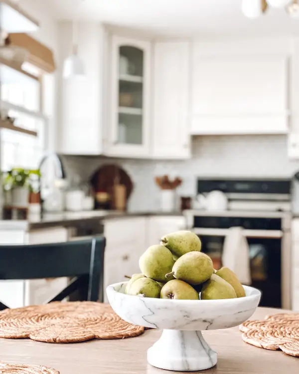 beautiful marble pedestal bowl of green pears is a great kitchen counter decor idea