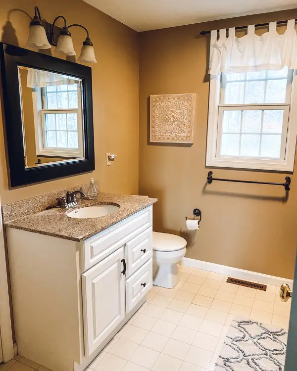 Before the bathroom makeover, there was a white linoleum floor and single white vanity