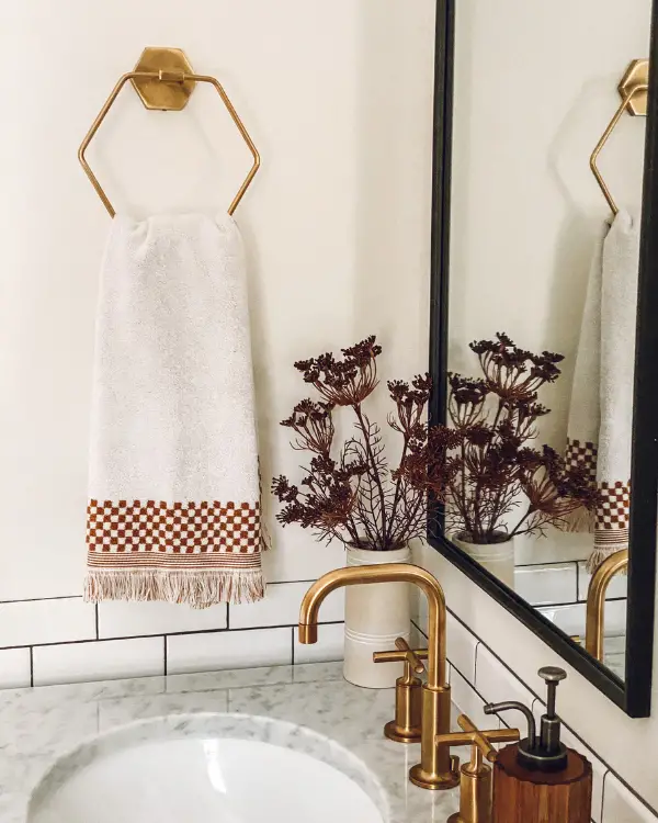 A towel ring and gold faucets as part of the bathroom makeover