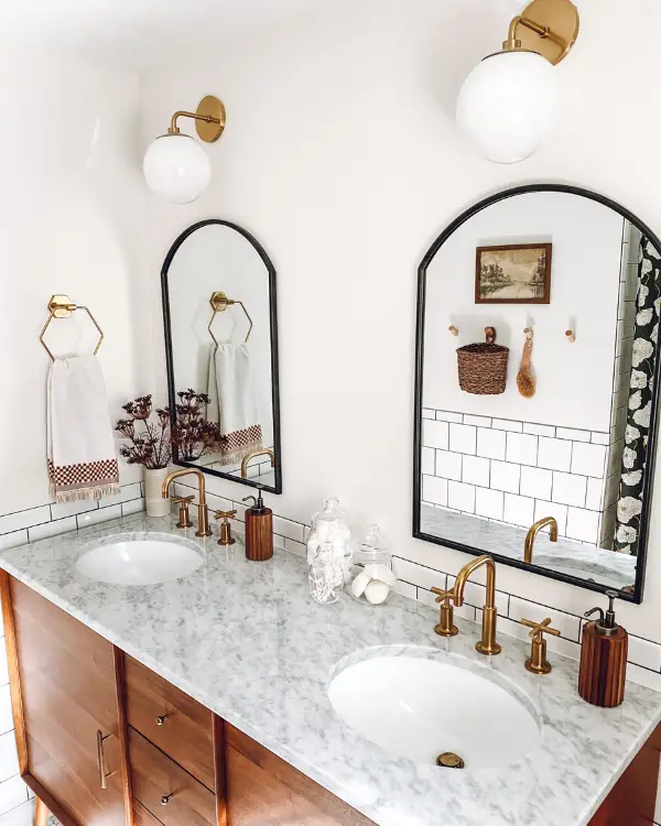 Part of this bathroom makeover was adding two black mirrors and midcentury globe sconces