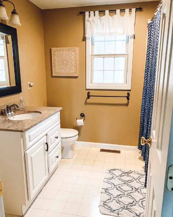 Before the bathroom remodel, there was a linoleum floor and single vanity.