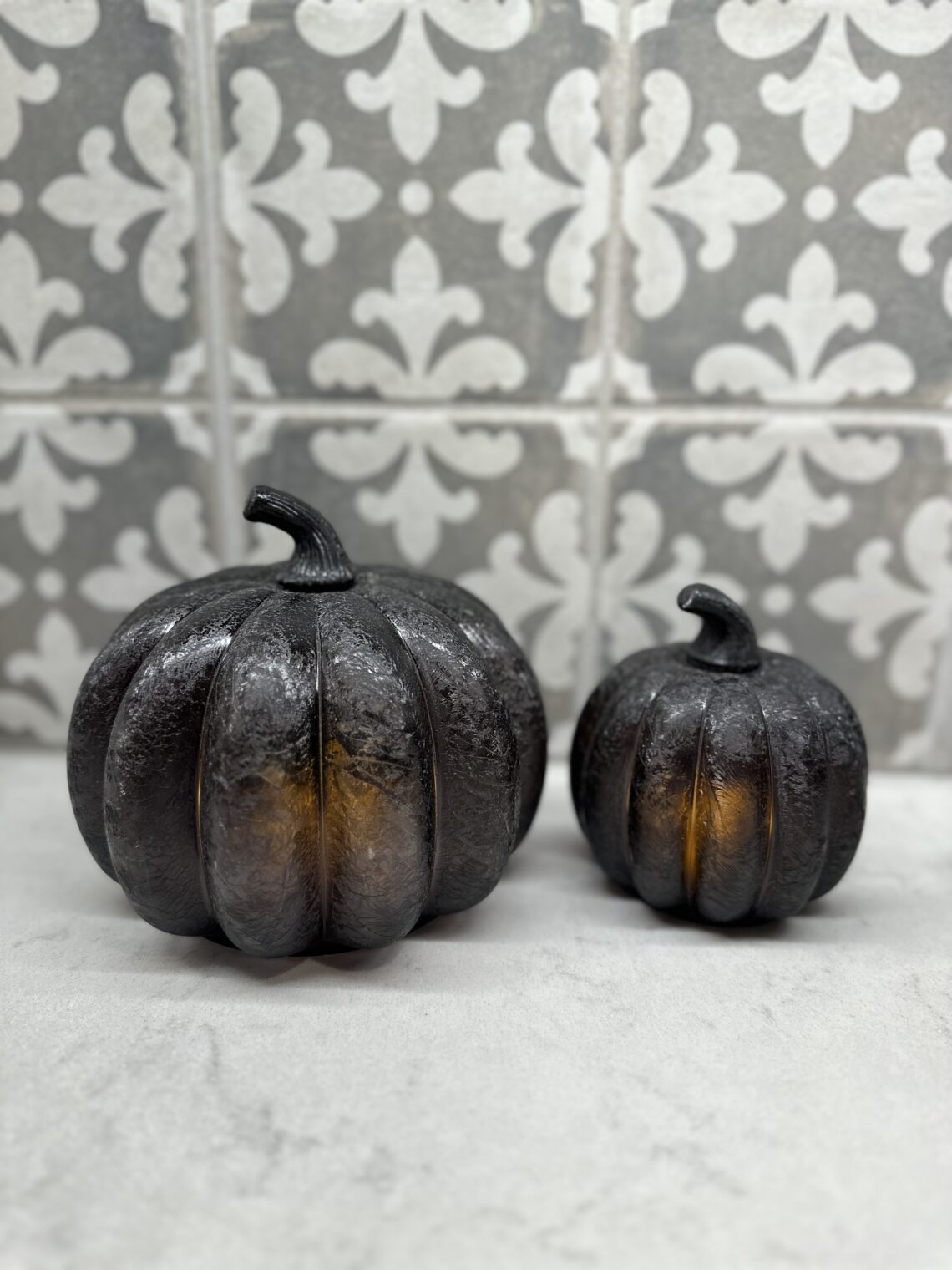 2 black glass pumpkins lit up showing a simple fall decor idea