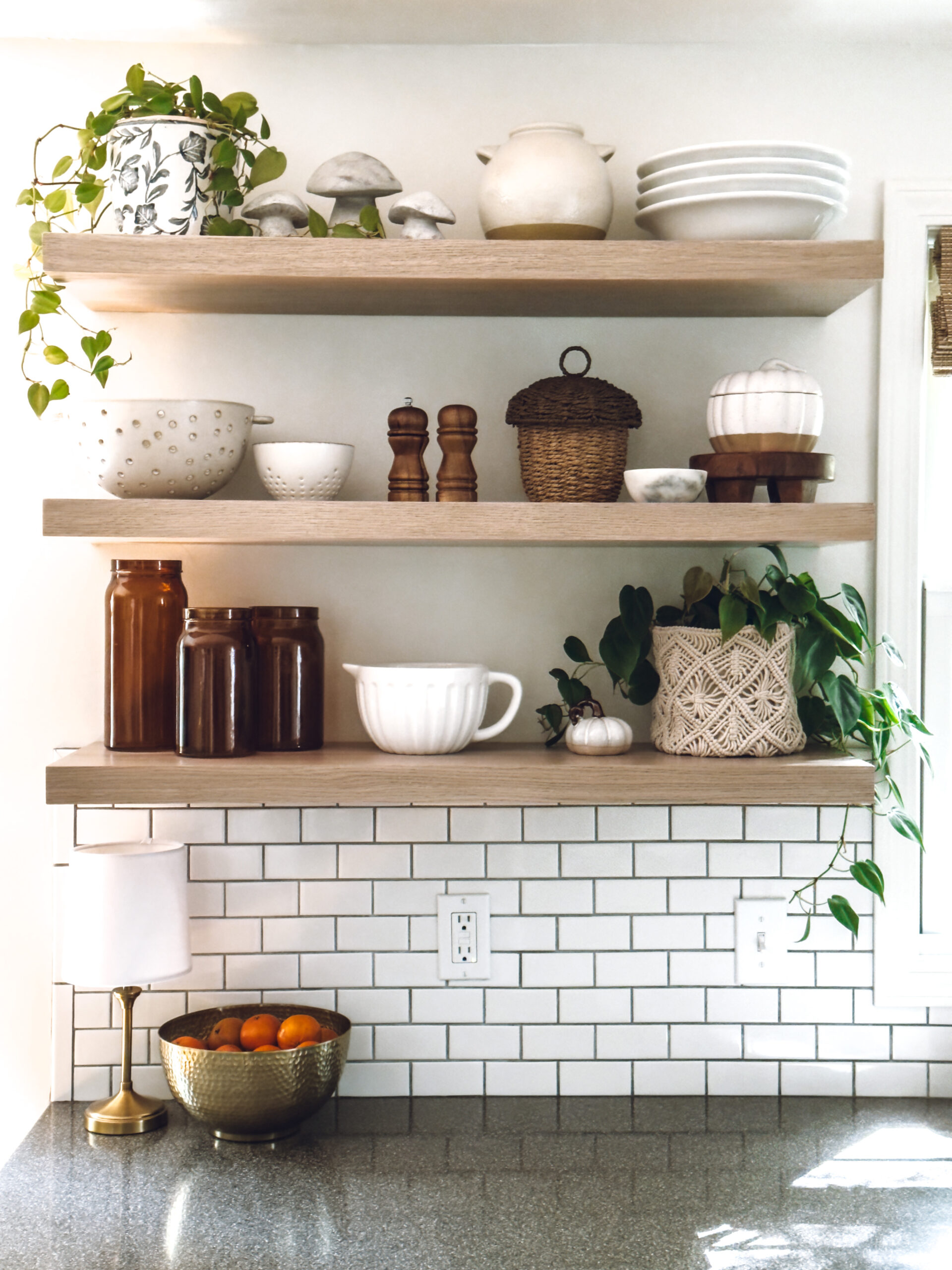 mushrooms, an acorn basket, pumpkin canister and amber glass jars on the kitchen shelves for simple fall decor ideas for the home