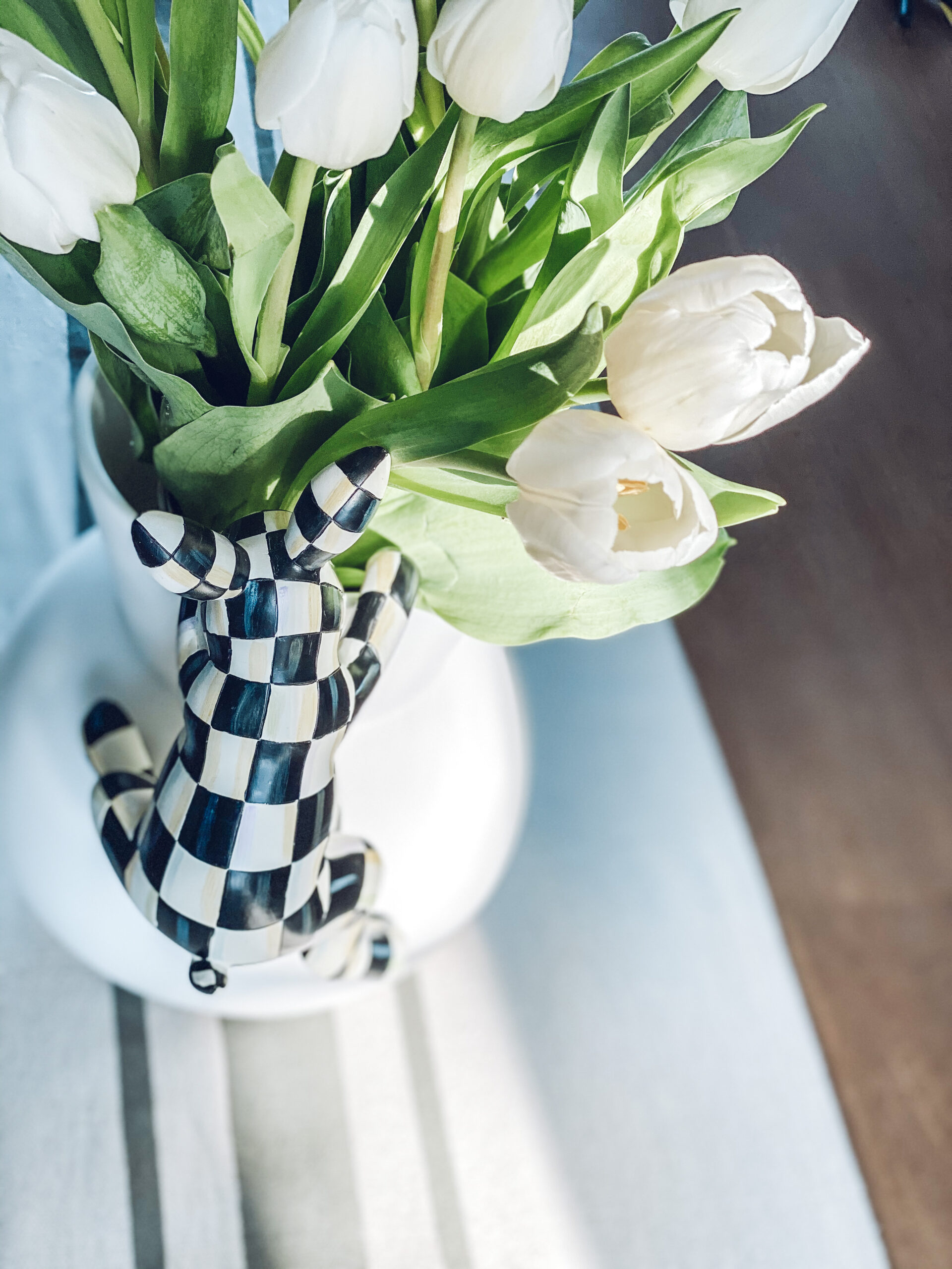 a black and white checkered bunny and white tulips