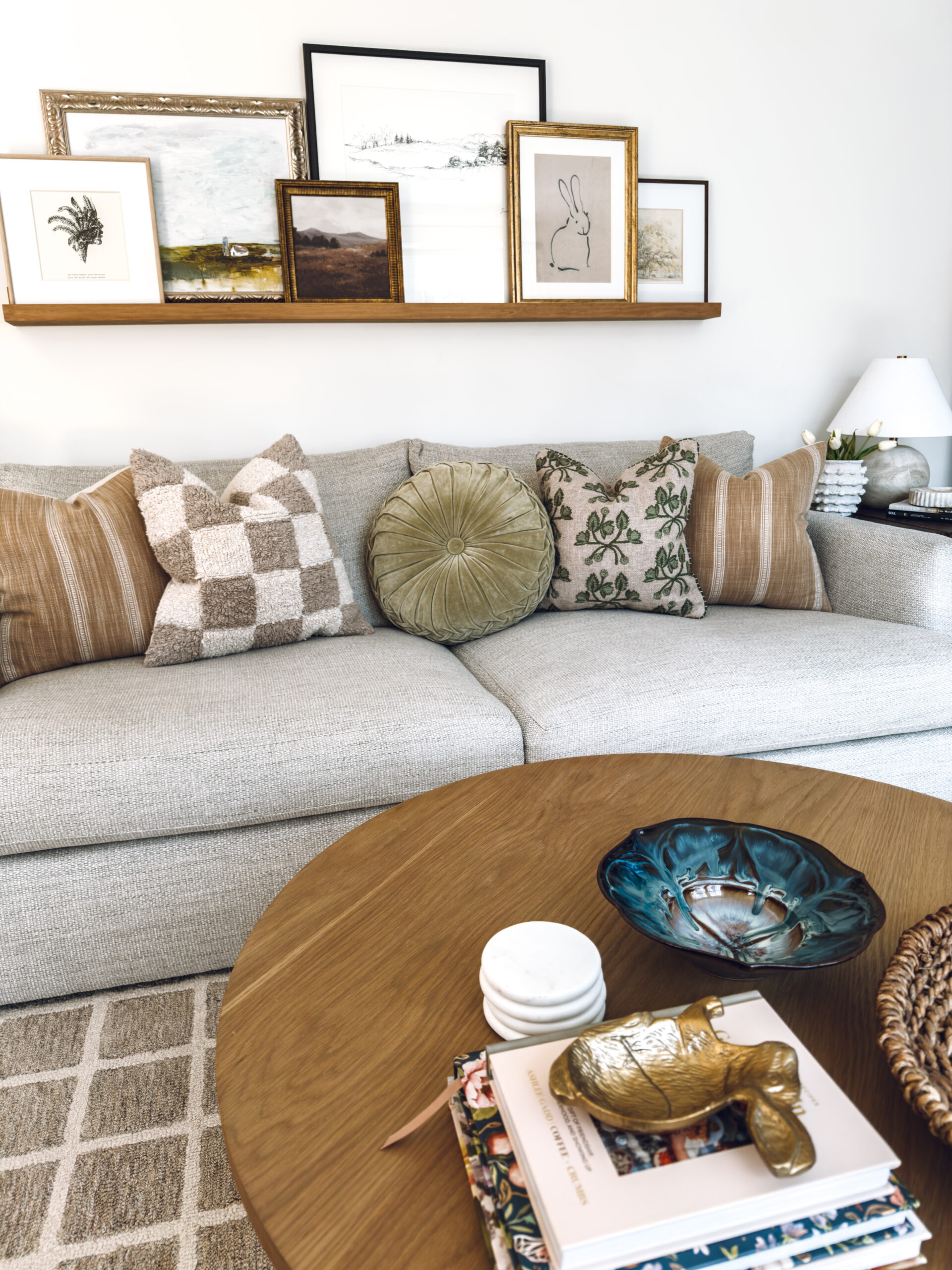 couch with a spring pillow with an art ledge hanging above with a piece of bunny art