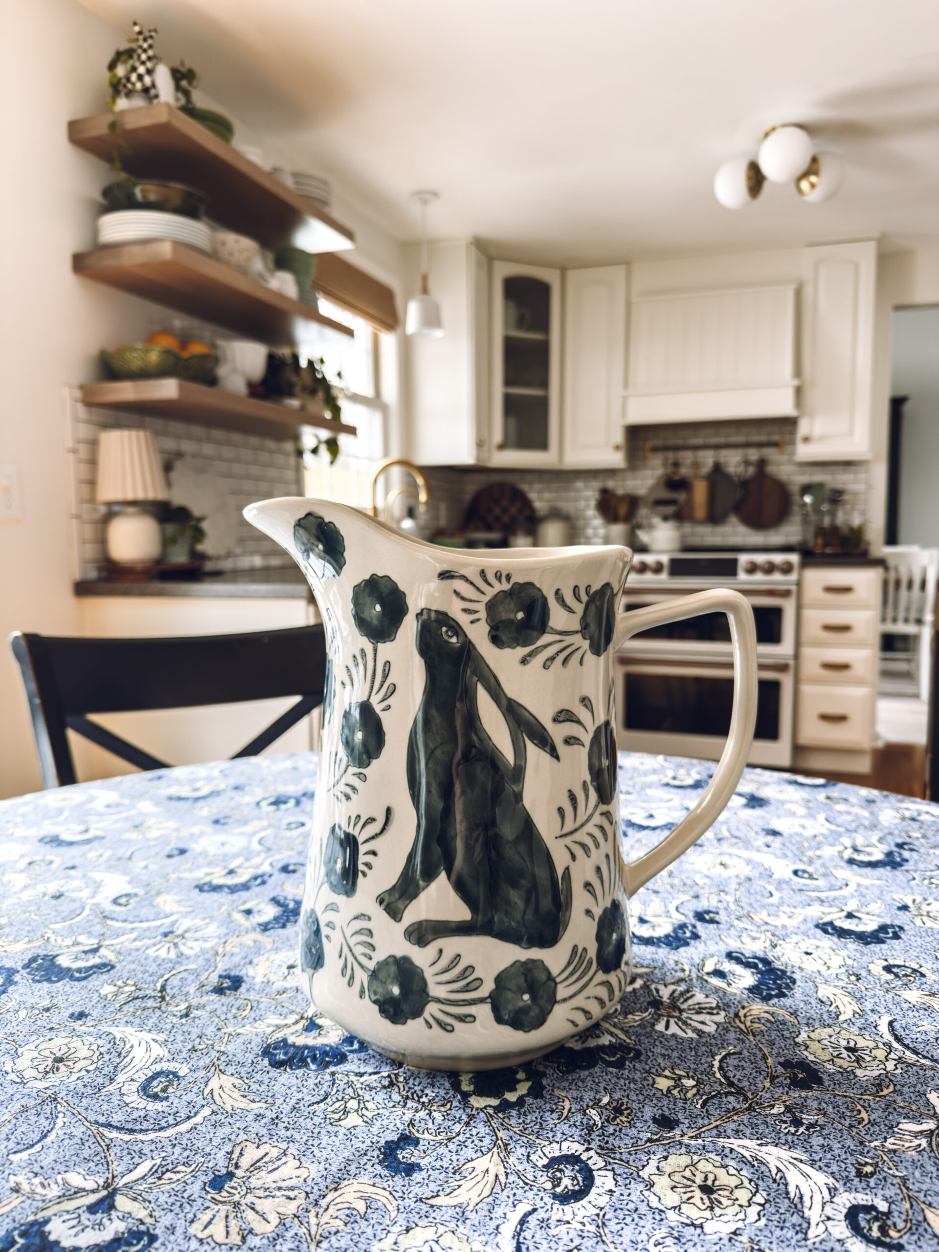 blue and white bunny pitcher on blue floral tablecloth for spring